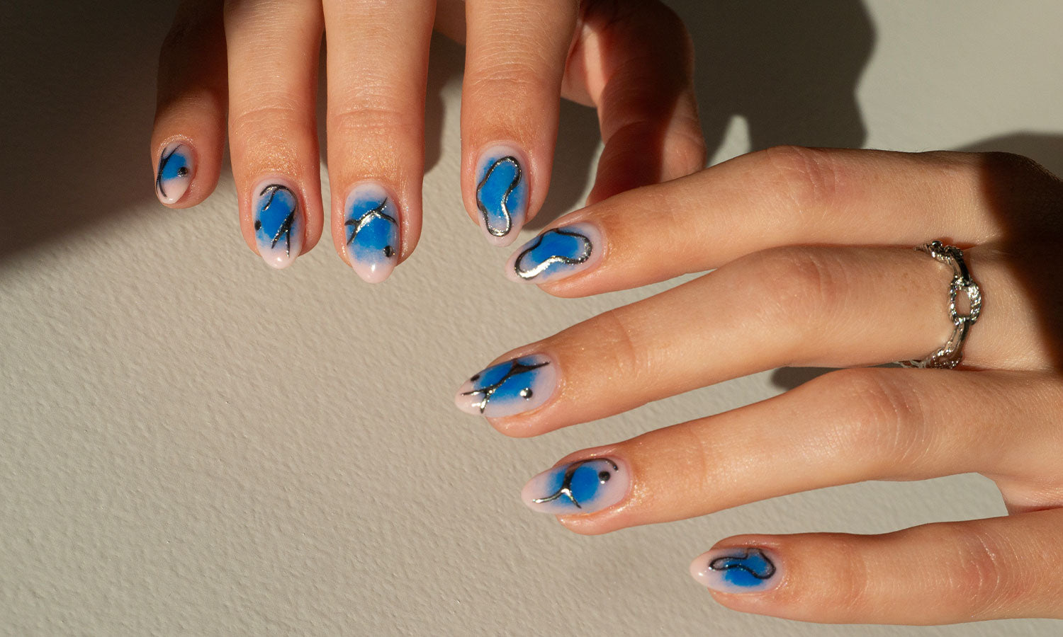 Gelous Blue Aura and Silver Chrome Gel Nail Polish Art - photographed in United Kingdom on model